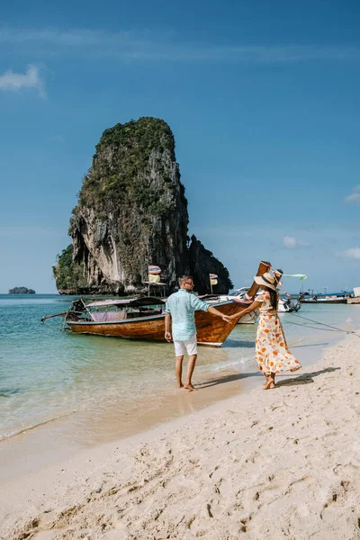 Railay Beach Krabi Thaïlande, couple marchant le matin sur la plage avec des falaises tropicales et des bateaux à longue queue sur le fond à l'île de Railay plage Krabi — Photo