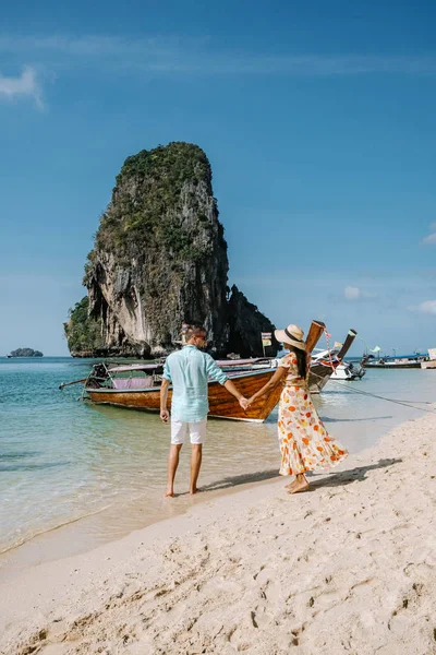 Railay Beach Krabi Thaïlande, couple marchant le matin sur la plage avec des falaises tropicales et des bateaux à longue queue sur le fond à l'île de Railay plage Krabi — Photo