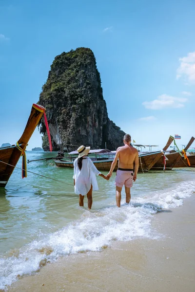 Railay Beach Krabi Thailand, Paar spaziert morgens am Strand mit tropischen Klippen und langen Schwanzbooten im Hintergrund am Insel Railay Strand Krabi — Stockfoto