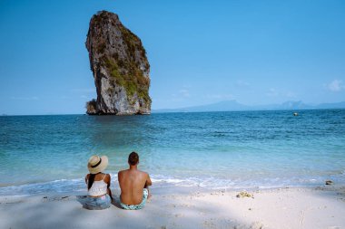 Kumsaldaki çift, Koh Poda Tayland, Tayland 'ın Krabi ilindeki Poda Adası' nın güzel manzarası. Bu adanın beyaz kumsalı var ve kristal berrak suyla çevrili.