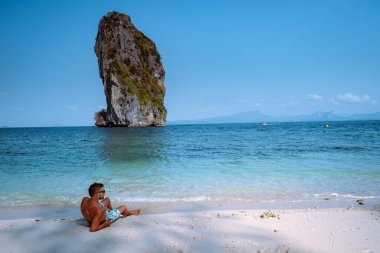 Koh Poda Tayland sahilindeki gençler, Tayland 'ın Krabi eyaletindeki Koh Poda veya Poda Adası' nın güzel manzarası. Bu adanın beyaz kumsalı var ve kristal berrak suyla çevrili.