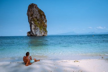 Koh Poda Tayland sahilindeki gençler, Tayland 'ın Krabi eyaletindeki Koh Poda veya Poda Adası' nın güzel manzarası. Bu adanın beyaz kumsalı var ve kristal berrak suyla çevrili.