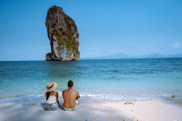 Kumsaldaki çift, Koh Poda Tayland, Tayland 'ın Krabi ilindeki Poda Adası' nın güzel manzarası. Bu adanın beyaz kumsalı var ve kristal berrak suyla çevrili.