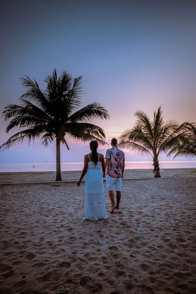 На Тайланде пара наблюдает за закатом на пляже в Таиланде — стоковое фото