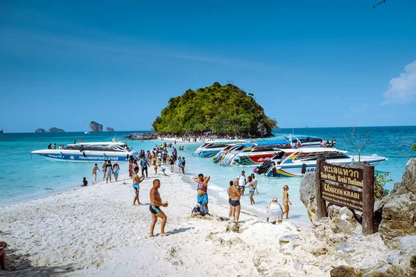 2019年1月1日，在泰国克拉比，人们走在白色热带海滩上，铁路海滩上，背景上的长尾船将游客抛下 — 图库照片