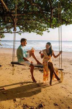 Krabi Tayland sahilinde hamak, Ao Nang sahilinde salıncakta sallanan çift Tayland yengeci