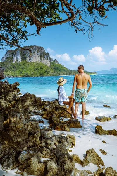 Тап Илсанд в Таиланде, пара мужчин и женщин на пляже, наблюдающих за чистым океаном — стоковое фото