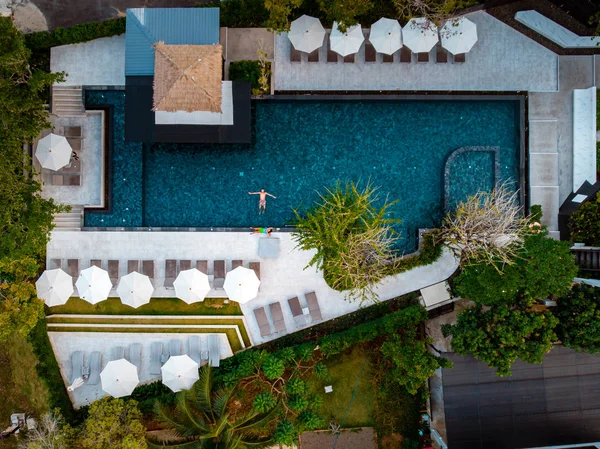 Vista superior piscina, piscina con vistas al dron, pareja en la piscina durante las vacaciones — Foto de Stock
