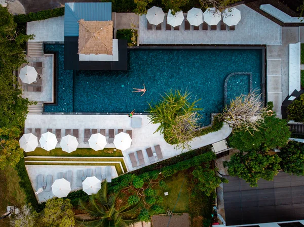 Vista superior piscina, piscina con vistas al dron, pareja en la piscina durante las vacaciones — Foto de Stock