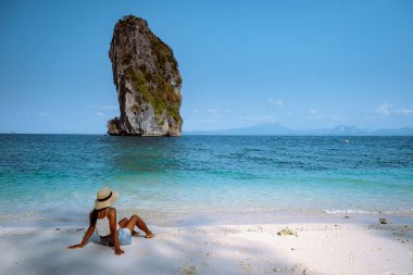 Koh Poda Krabi Thailand, white beach with crystal clear water in Krabi Thailand, woman with hat on the beach