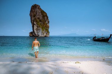 men in swim short on the beach, Koh Poda Krabi Thailand, white beach with crystal clear water in Krabi Thailand