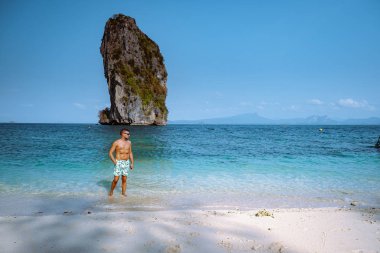 men in swim short on the beach, Koh Poda Krabi Thailand, white beach with crystal clear water in Krabi Thailand