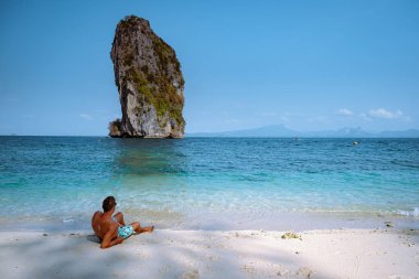 men in swim short on the beach, Koh Poda Krabi Thailand, white beach with crystal clear water in Krabi Thailand