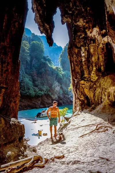 Playa oculta con enorme cueva cerca de Koh Poda Island Krabi Tailandia, los hombres en un acantilado de piedra caliza con vistas a la playa secreta en Koh Poda Krabi Tailandia , — Foto de Stock