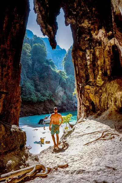 Playa oculta con enorme cueva cerca de Koh Poda Island Krabi Tailandia, los hombres en un acantilado de piedra caliza con vistas a la playa secreta en Koh Poda Krabi Tailandia , — Foto de Stock