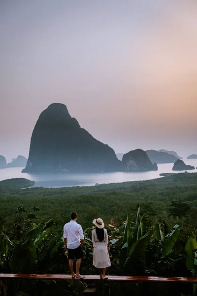 Pareja viendo amanecer en las montañas de la bahía de Phangnga durante el amanecer, pareja viendo amanecer en el mirador Samet Nang Shee Tailandia provincia de Phangnga — Foto de Stock