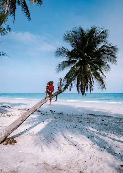 Couple climbing in palm tree in Thailand, Wua Laen beach Chumphon area Thailand, palm tree hanging over the beach with couple on vacation in Thailand — Stockfoto