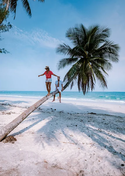 Pareja trepando en palmera en Tailandia, Wua Laen playa Chumphon zona Tailandia, palmera colgando sobre la playa con pareja de vacaciones en Tailandia — Foto de Stock