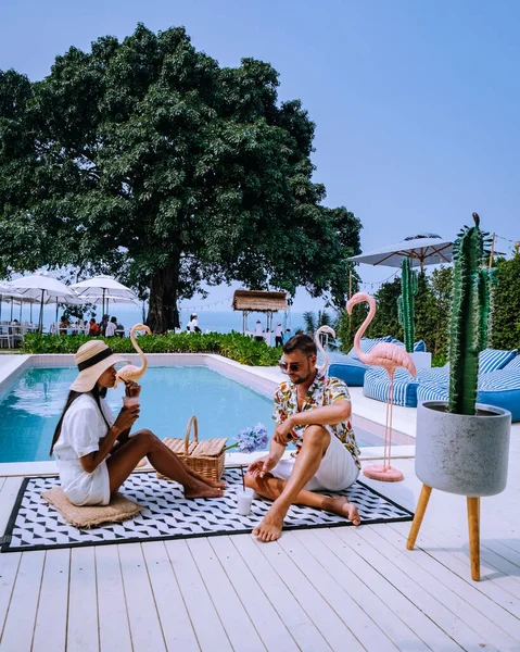 Pareja de hombres y mujeres relajarse en la piscina retro, hombres y mujeres en la piscina durante las vacaciones en Tailandia, ajuste vintage — Foto de Stock
