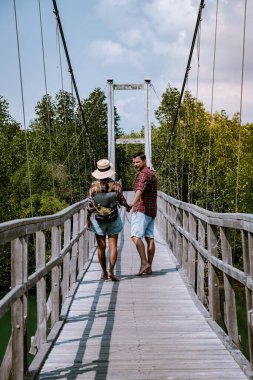 Chumphon Ulusal Parkı, Tayland, parktaki ahşap güvertede ağaçlar ve mangrovlarla yürüyen çift Chumphon Tayland 'da