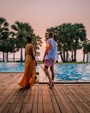 couple in swimming pool during a luxury vacation in Thailand, men and woman at luxury hotel resort in Thailand holiday in Asia