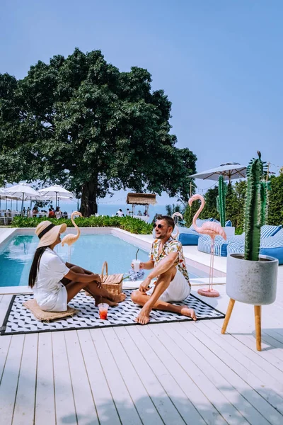 Coppia uomini e donne rilassarsi in piscina retrò, uomini e donne in piscina durante le vacanze in Thailandia, ambiente vintage — Foto Stock