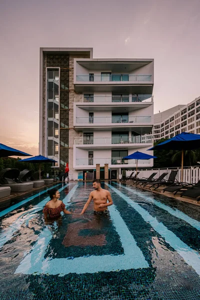 Couple in swimming pool during a luxury vacation in Thailand, men and woman at luxury hotel resort in Thailand holiday in Asia — Stock Photo, Image