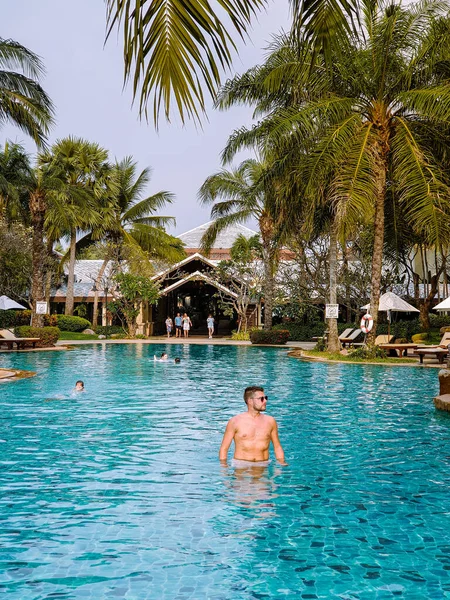 Homens na piscina durante umas férias de luxo na Tailândia, homens e mulheres no resort hotel de luxo na Tailândia férias na Ásia — Fotografia de Stock