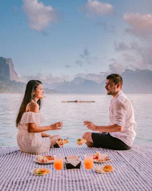 Güneş doğarken Phangnga Körfezi 'nde, Samet Nang Shee Tayland Phangnga bölgesinden güneşin doğuşunu izleyen çift.
