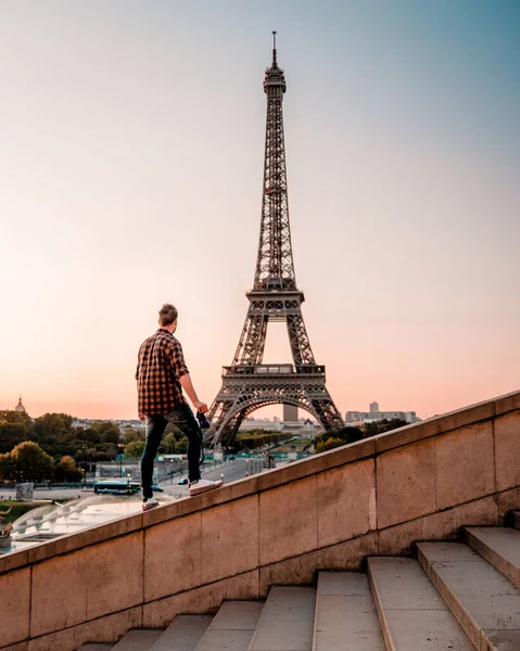 young men watching Eiffel tower in Paris. guy tourist visiting Paris France by eiffel tower