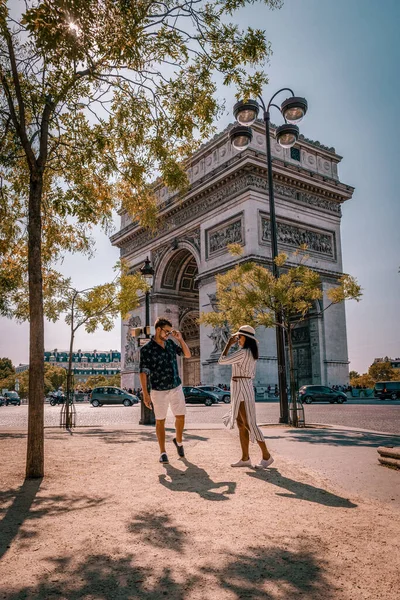 Avenue des Champs Elysees Paris, пара мужчин и женщин в champs elysees paris, Молодые пары мужчины и женщины во время поездки по городу в Париже — стоковое фото