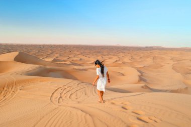 Dubai dessert sand dunes, couple on Dubai desert safari,United Arab Emirates, woman vacation in Dubai