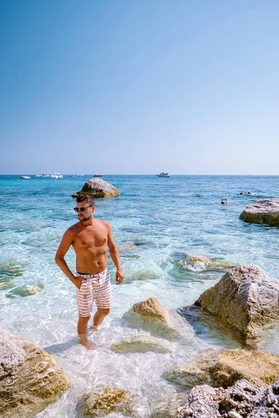 Cerdeña costa de Orosei Italia, chico de vacaciones en la isla de Cerdeña en un viaje en barco a todas las playas de guijarros blancos algunas de las playas más bellas de Europa — Foto de Stock