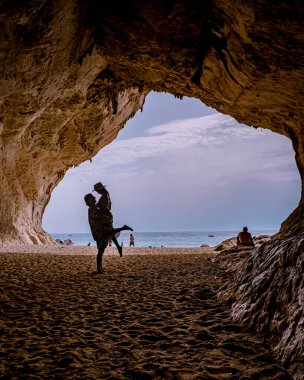 Sardinia Orosei coast Italy, men and woman, young couple adult on vacation at the Island of Sardinia on a boat trip to all the white pebble beaches some of the most beautiful beaches in Europe 