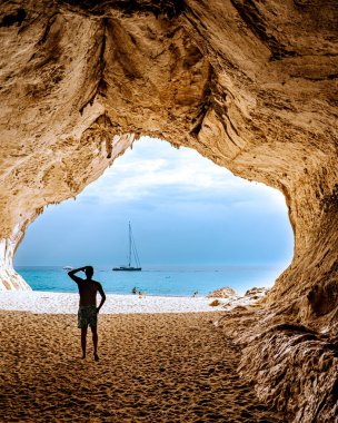 Sardinia Orosei coast Italy, guy on vacation at the Island of Sardinia on a boat trip to all the white pebble beaches some of the most beautiful beaches in Europe 