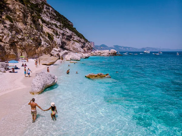 Cerdeña Costa de Orosei Italia, hombres y mujeres, pareja de jóvenes adultos de vacaciones en la isla de Cerdeña en un viaje en barco a todas las playas de guijarros blancos algunas de las playas más bellas de Europa — Foto de Stock