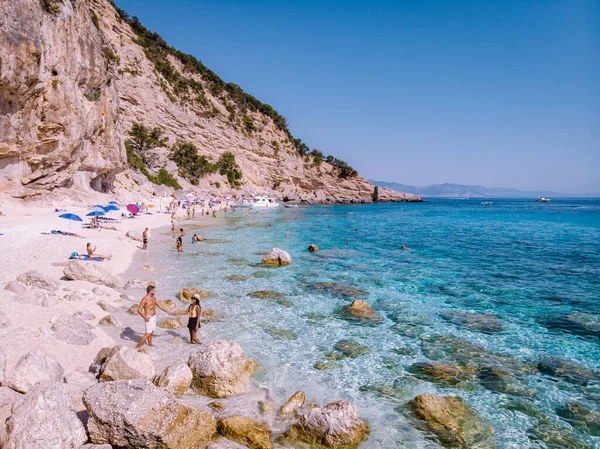 Cerdeña Costa de Orosei Italia, hombres y mujeres, pareja de jóvenes adultos de vacaciones en la isla de Cerdeña en un viaje en barco a todas las playas de guijarros blancos algunas de las playas más bellas de Europa — Foto de Stock