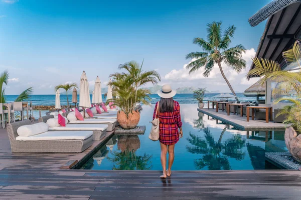 Luxury swimming pool in tropical resort, relaxing holidays in Seychelles islands. La Digue, Young man during sunset by swimpool — Stok fotoğraf