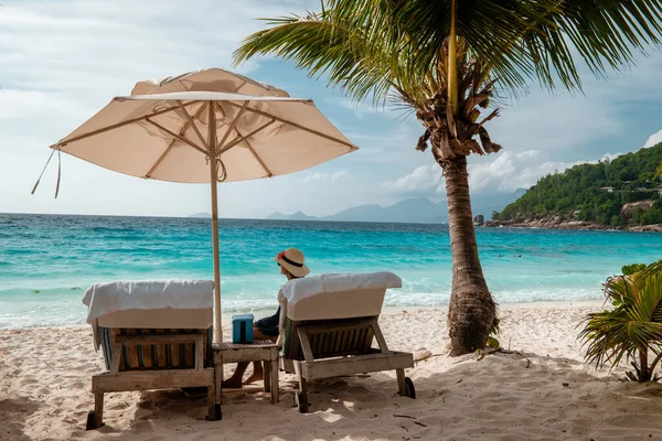 Piscina de luxo em resort tropical, férias relaxantes nas ilhas Seychelles. La Digue, Jovem durante o pôr-do-sol por piscina — Fotografia de Stock