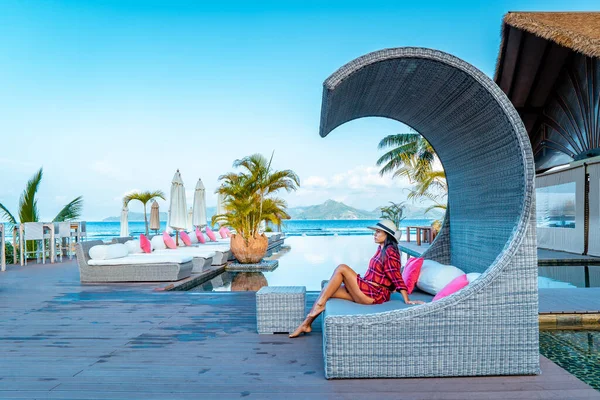 Piscina di lusso in località tropicale, vacanze rilassanti nelle isole Seychelles. La Digue, Giovane durante il tramonto in piscina — Foto Stock