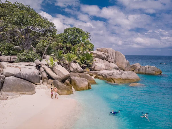 Seychelles tropical Island, Mujer joven y hombres en la playa blanca durante las vacaciones de vacaciones Mahe Seychelles, Praslin Seychelles — Foto de Stock