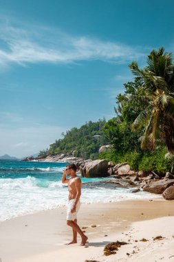 Seychelles tropical Island, Young man on the white beach during Holiday vacation Mahe Seychelles, Praslin Seychelles