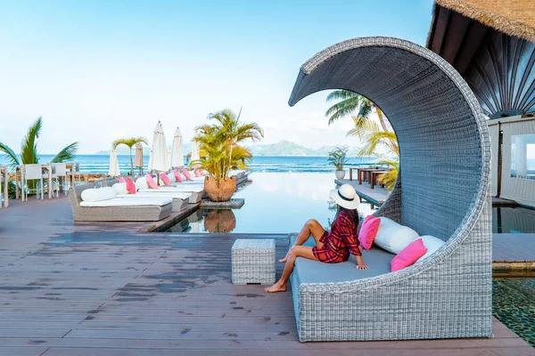 Luxury swimming pool in tropical resort, relaxing holidays in Seychelles islands. La Digue, Young man during sunset by swimpool — Stockfoto