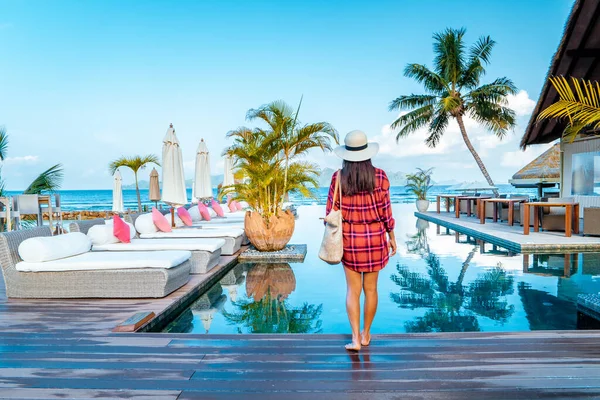 Piscina di lusso in località tropicale, vacanze rilassanti nelle isole Seychelles. La Digue, Giovane durante il tramonto in piscina — Foto Stock