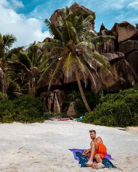 La Digue Seychely, mladý muž v neformálním oblečení na pláži v Anse Source dargent, La Digue Seychely, poblíž Praslin a Mahe Island — Stock fotografie
