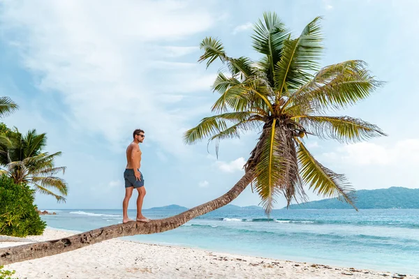 La Digue Seychelles,young man in casual clothes on the beach at Anse Source dArgent, LA Digue Seychelles , near Praslin and Mahe Island — Stock Photo, Image
