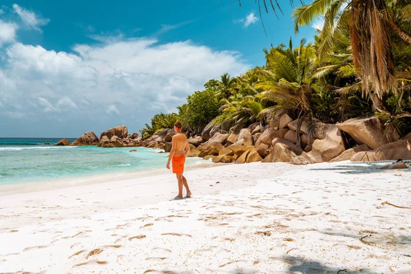 La Digue Seychellen, jongeman in casual kleding op het strand bij Anse Source dargent, La Digue Seychellen, in de buurt van Praslin en Mahe Island — Stockfoto