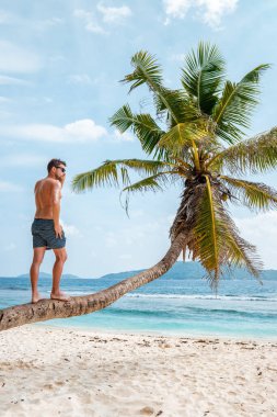 La Digue Seyşeller, Anse Source Dargent sahilinde, Praslin ve Mahe Adası yakınlarındaki La Digue Seychelles 'de günlük giysiler içinde genç bir adam.