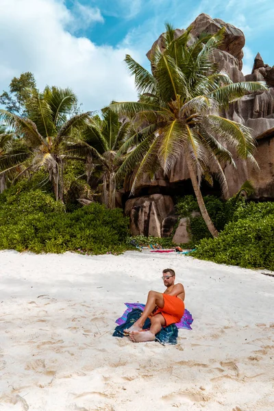 La Digue Seychely, mladý muž v neformálním oblečení na pláži v Anse Source dargent, La Digue Seychely, poblíž Praslin a Mahe Island — Stock fotografie