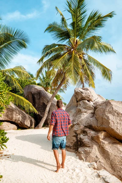 La Digue Seychellen, jongeman in casual kleding op het strand bij Anse Source dargent, La Digue Seychellen, in de buurt van Praslin en Mahe Island — Stockfoto